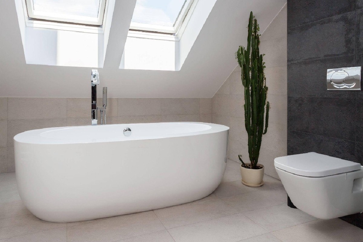Helles Badezimmer mit freistehender Badewanne und Dachfenster – professionelle Badsanierung in Stuttgart.