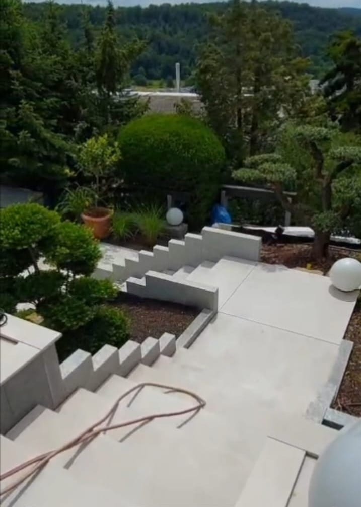 Moderne Außentreppe mit großformatigen Fliesen und minimalistischer Gartengestaltung in Stuttgart – professionelle Fliesenverlegung im Außenbereich.