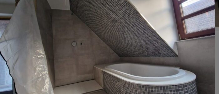 Luxuriöses Badezimmer mit eingelassener Mosaik-Badewanne unter Dachschräge – Renovierung in Stuttgart.
